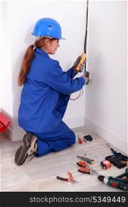 Female electrician checking socket