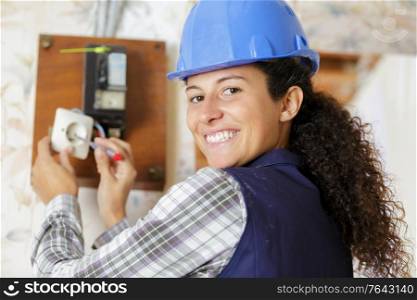 female electrician fixing socket electricity problem