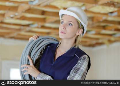 female electrician holding cable indoors