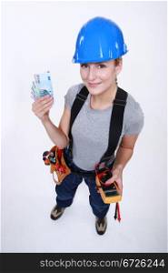 Female electrician holding wedge of cash
