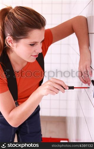 Female electrician installing a wall socket