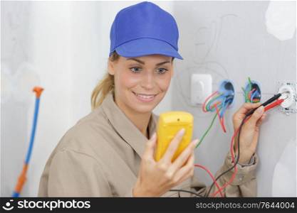 female electrician testing a wall socket