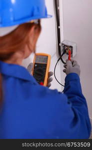 Female electrician using a voltmeter