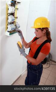 Female electrician with a fuse box