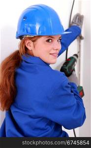 Female electrician with a power drill