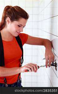 Female electrician working in the bathroom