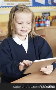 Female Elementary School Pupil Using Digital Tablet In Class