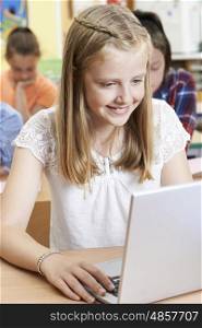 Female Elementary School Pupil Using Laptop In Computer Class