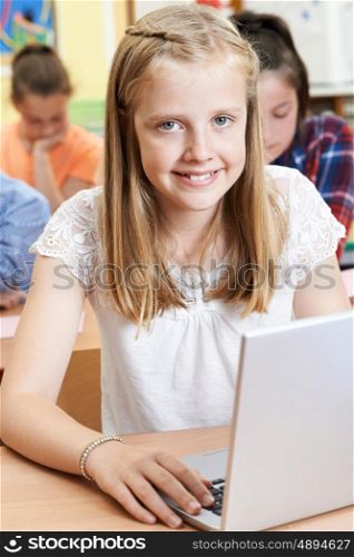 Female Elementary School Pupil Using Laptop In Computer Class