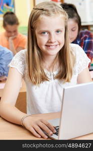 Female Elementary School Pupil Using Laptop In Computer Class