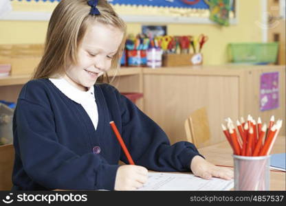 Female Elementary School Pupil Working At Desk