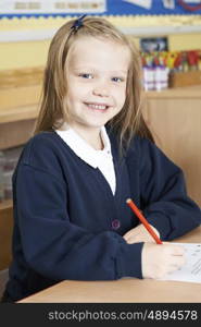 Female Elementary School Pupil Working At Desk