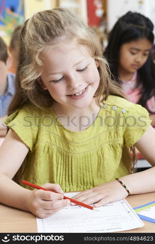 Female Elementary School Pupil Working At Desk