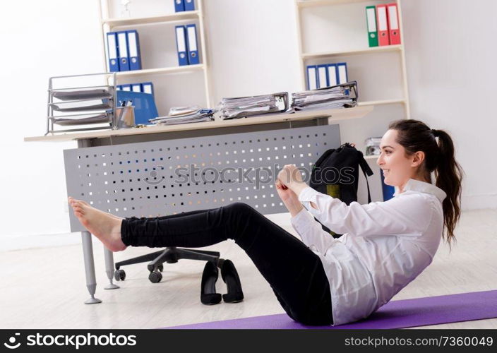 Female employee doing sport exercises in the office 