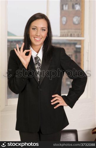 Female employee wearing business suit gives OK hand signal