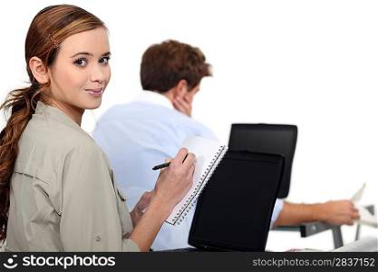 female employee writing notes near a colleague
