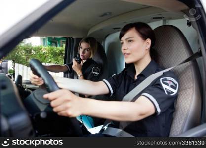 Female EMT calling dispatcher on radio - shallow depth of field, focus on woman with radio