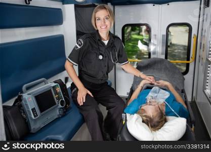 Female EMT professional in ambulance with senior woman patient