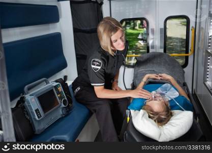 Female EMT worker tending to ill senior patient, listening to heart rate with stethoscope