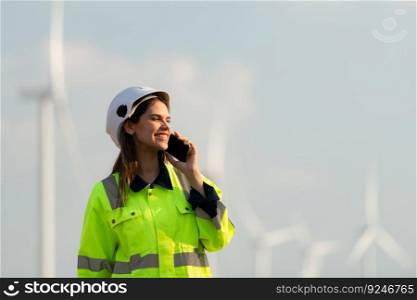 Female engineer at Natural Energy Wind Turbine site with the mission of being responsible for taking care of large wind turbines Use the phone to communicate with your family to get rid of missing you