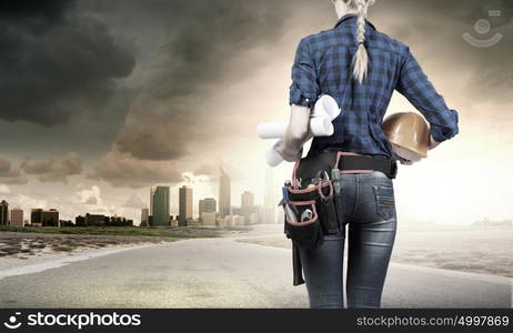 Female engineer. Bottom view of woman engineer with tool belt on waist