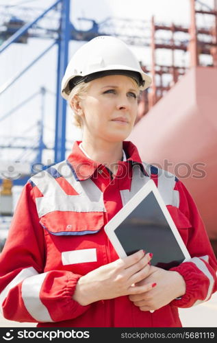 Female engineer holding tablet computer in shipping yard