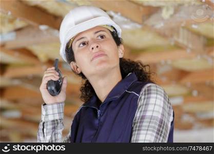 female engineer in white hard hats holding walkie-talkie