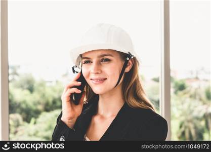 Female engineer or architect on phone and speaking with team.