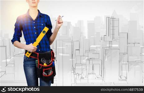 Female engineer. Young pretty woman engineer with tool belt on waist