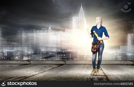 Female engineer. Young pretty woman engineer with tool belt on waist