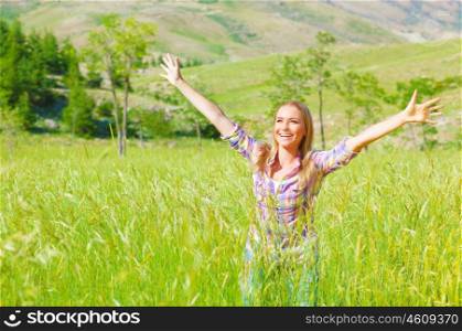 Female enjoying green field, hands up in fresh air, standing in spring wheat grass, freedom and happiness concept