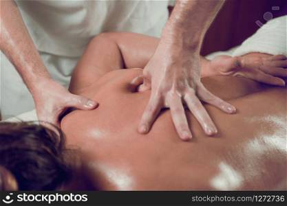Female Enjoying Relaxing Back and Shoulders Massage In Cosmetology Spa Center