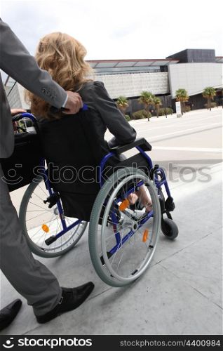 Female executive being pushed in wheelchair