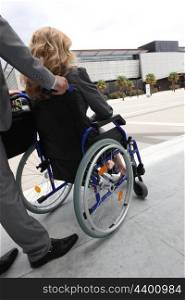 Female executive being pushed in wheelchair