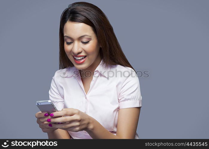 Female executive texting on mobile phone