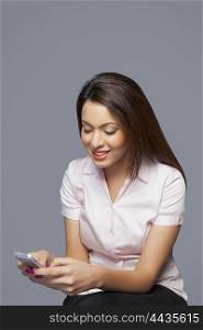 Female executive texting on mobile phone