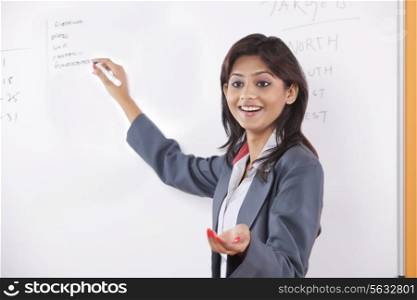 Female executive writing on white board
