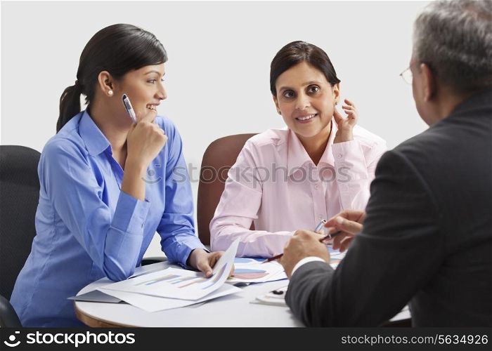 Female executives smiling while discussing with each other