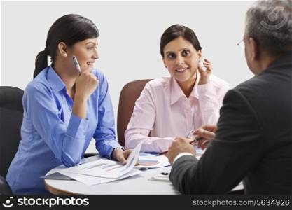 Female executives smiling while discussing with each other