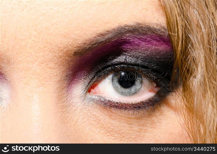 female eye close-up with make up in glam rock style