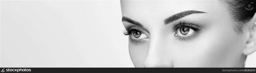 Female Eye with Extreme Long False Eyelashes. Eyelash Extensions. Makeup, Cosmetics, Beauty. Close up, Macro. Black and White photo