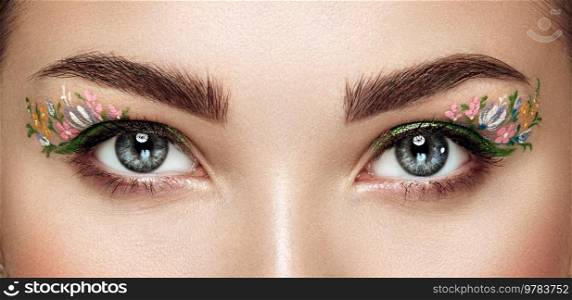Female eye with flower makeup eyes. Spring makeup. Beauty fashion. Eyelashes. Cosmetic Eyeshadow. Make-up detail. Close up, Macro