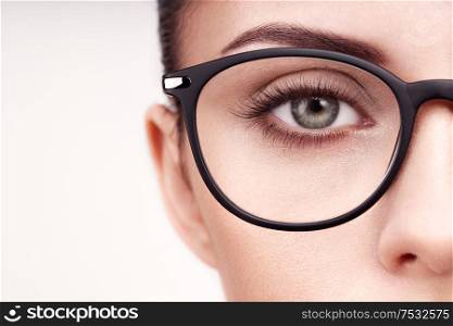 Female eye with long eyelashes in eyeglasses. Model in glasses. Vision correction. Poor eyesight. Spectacle frame. Makeup, cosmetics, beauty. Close up, macro