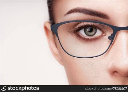 Female eye with long eyelashes in eyeglasses. Model in glasses. Vision correction. Poor eyesight. Spectacle frame. Makeup, cosmetics, beauty. Close up, macro