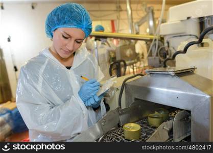 Female factory operative watching production line