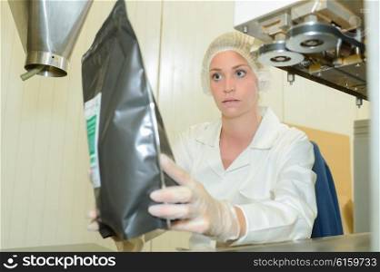 Female factory worker holding product in bag