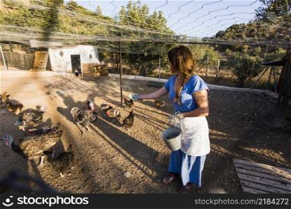 female farmer feeding chickens farm