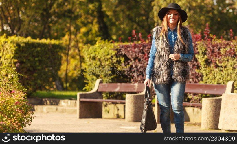 Female fashion. Attractive long haired model wearing stylish clothes walking in park. Fashionable young model spending time on air. . Stylish woman on air