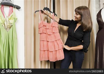 Female fashion designer looking at a dress and smiling