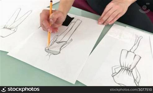 Female fashion designer sketching new dresses and models